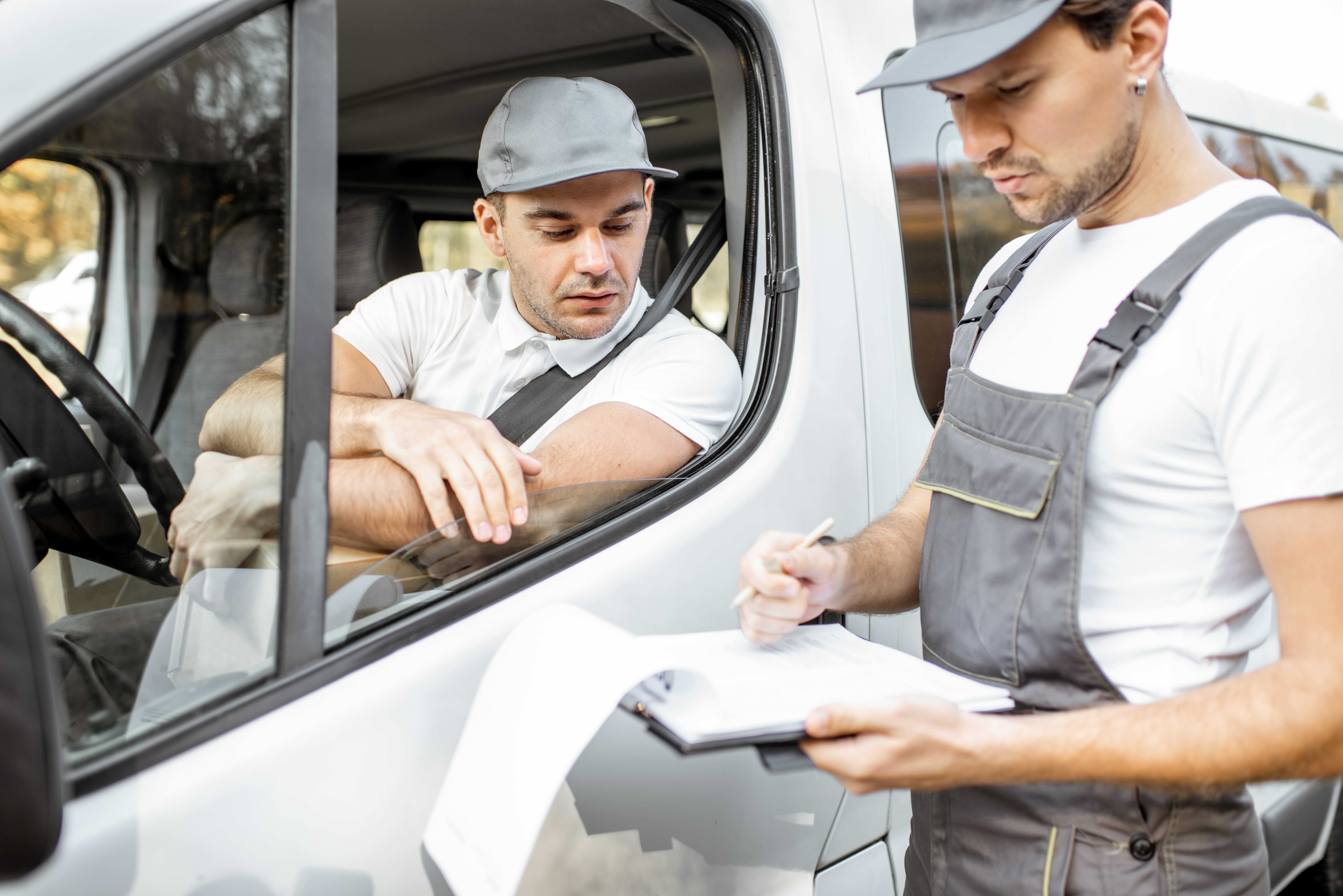 Trucj driver watches as an inspector works through a checklist